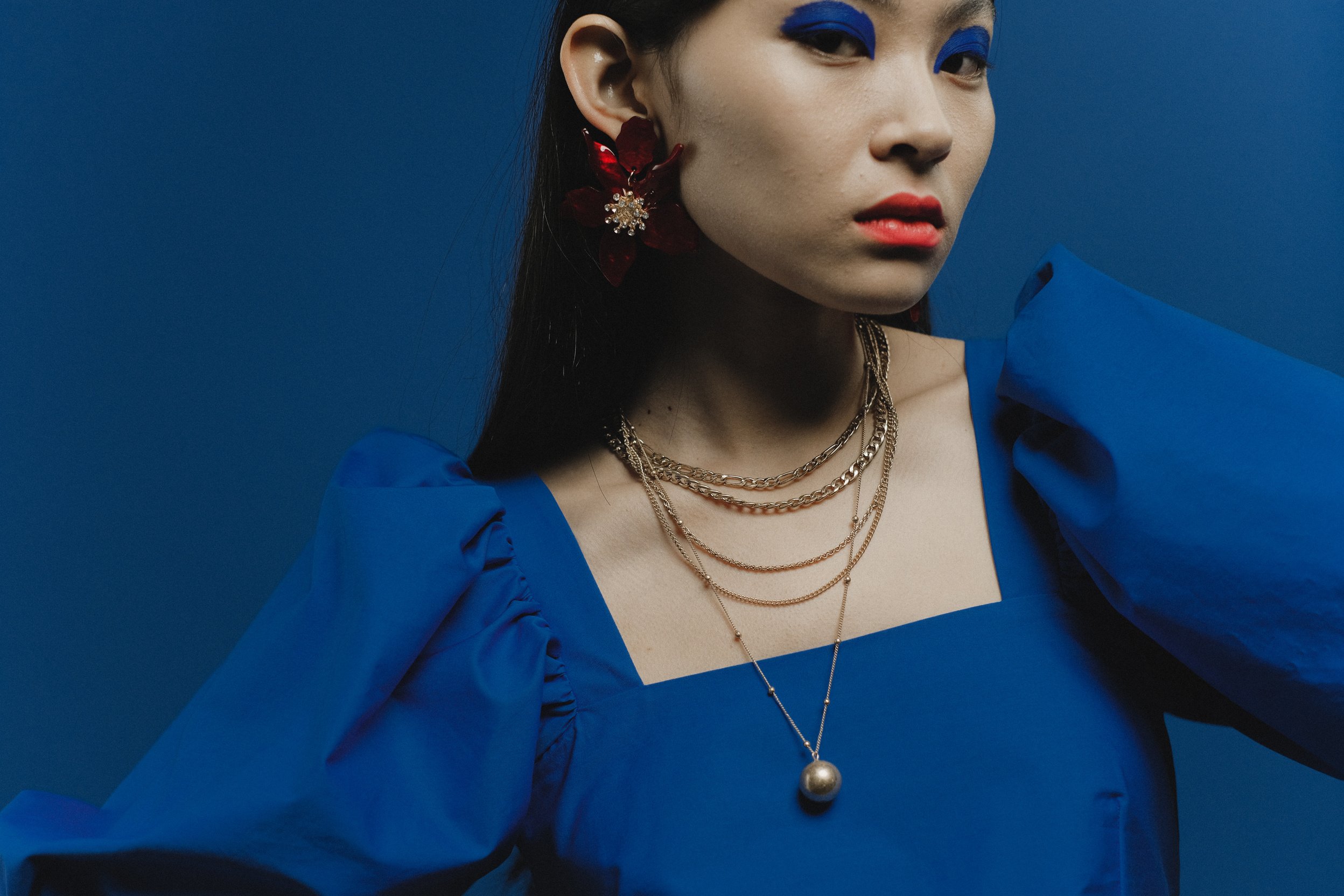 Woman in Blue Dress Wearing Gold Necklace